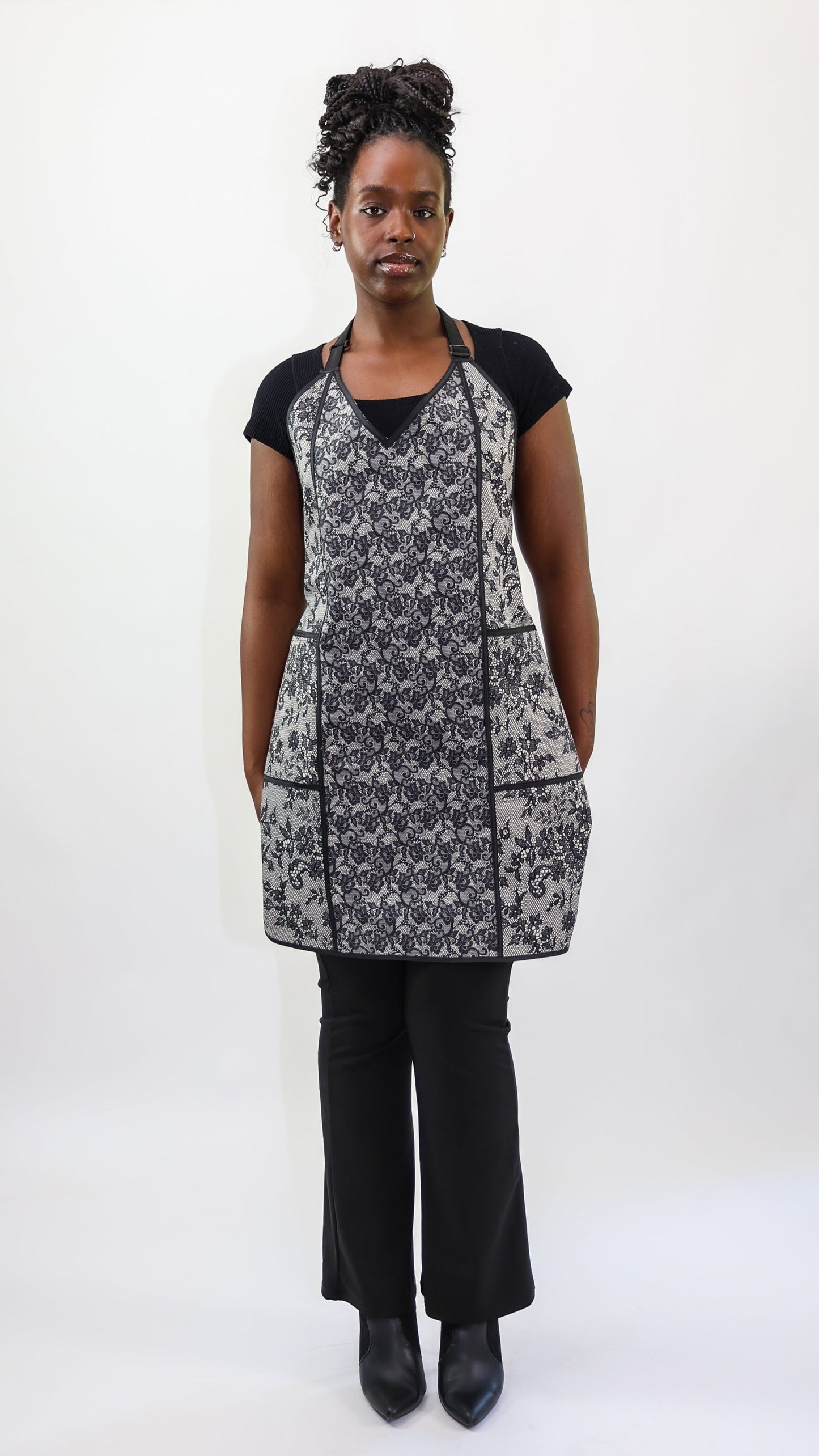 stylist wearing black and ivory lace apron