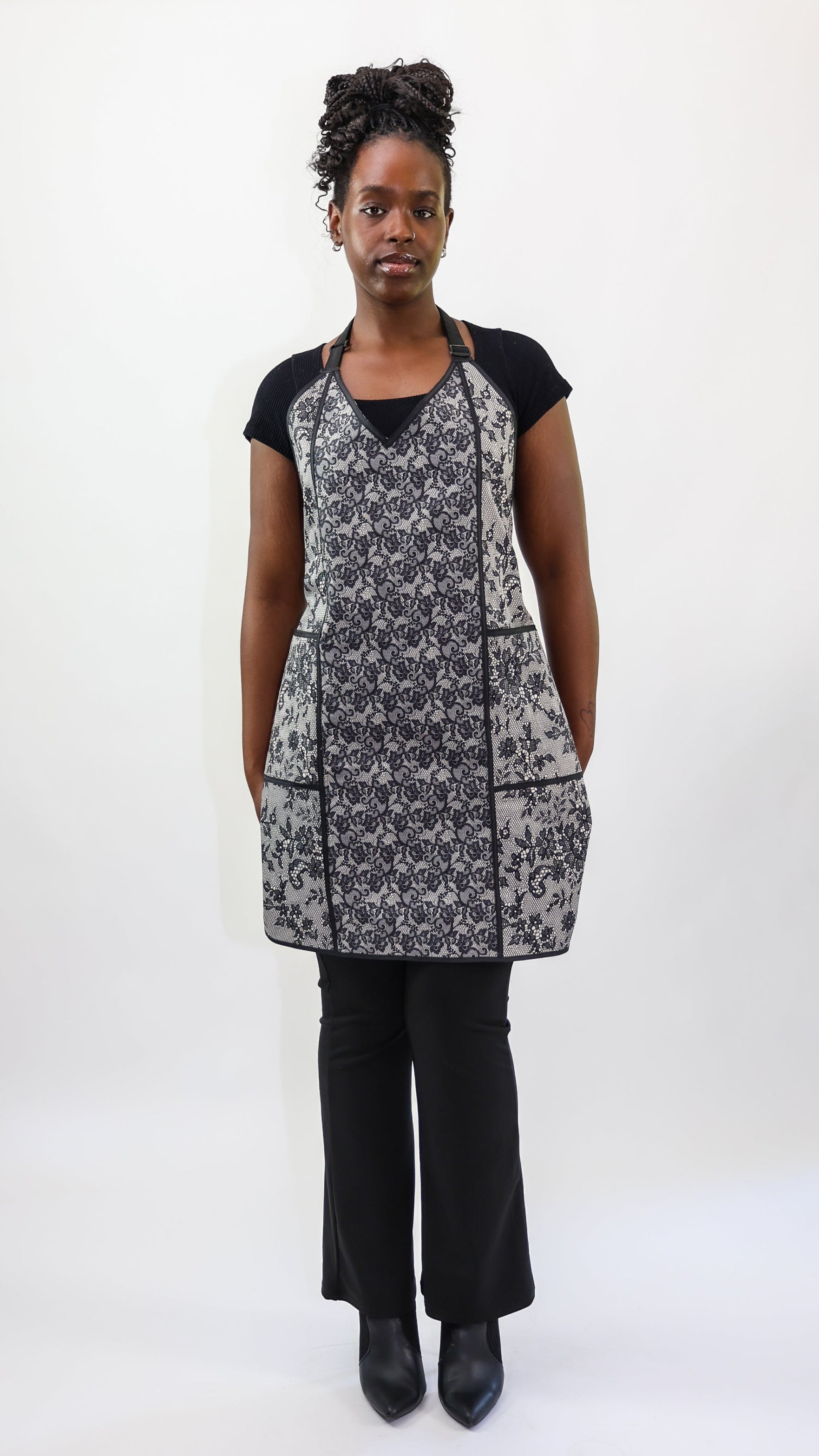 stylist wearing black and ivory lace apron