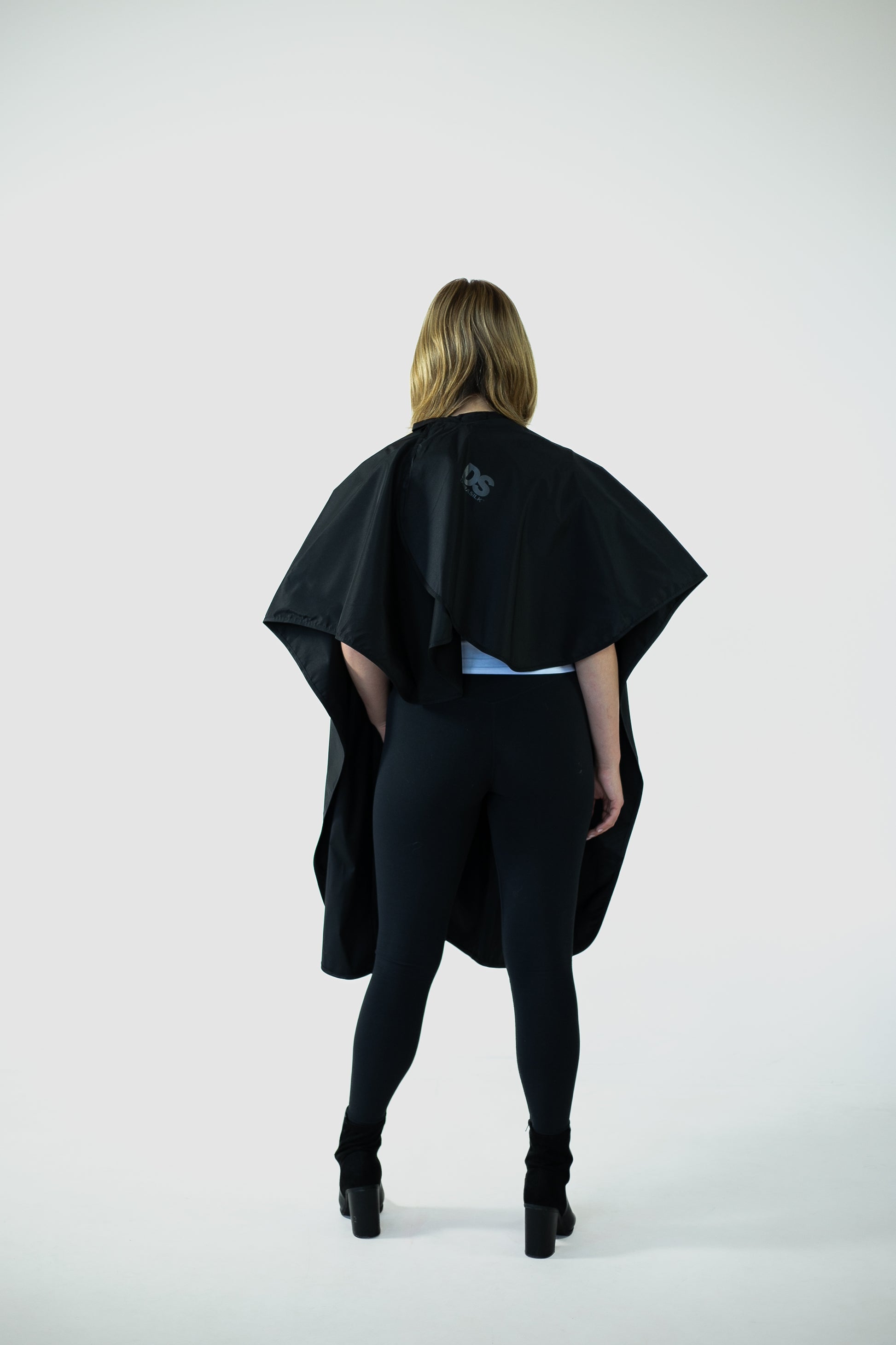 The back view of a woman adorned in a stylish cape