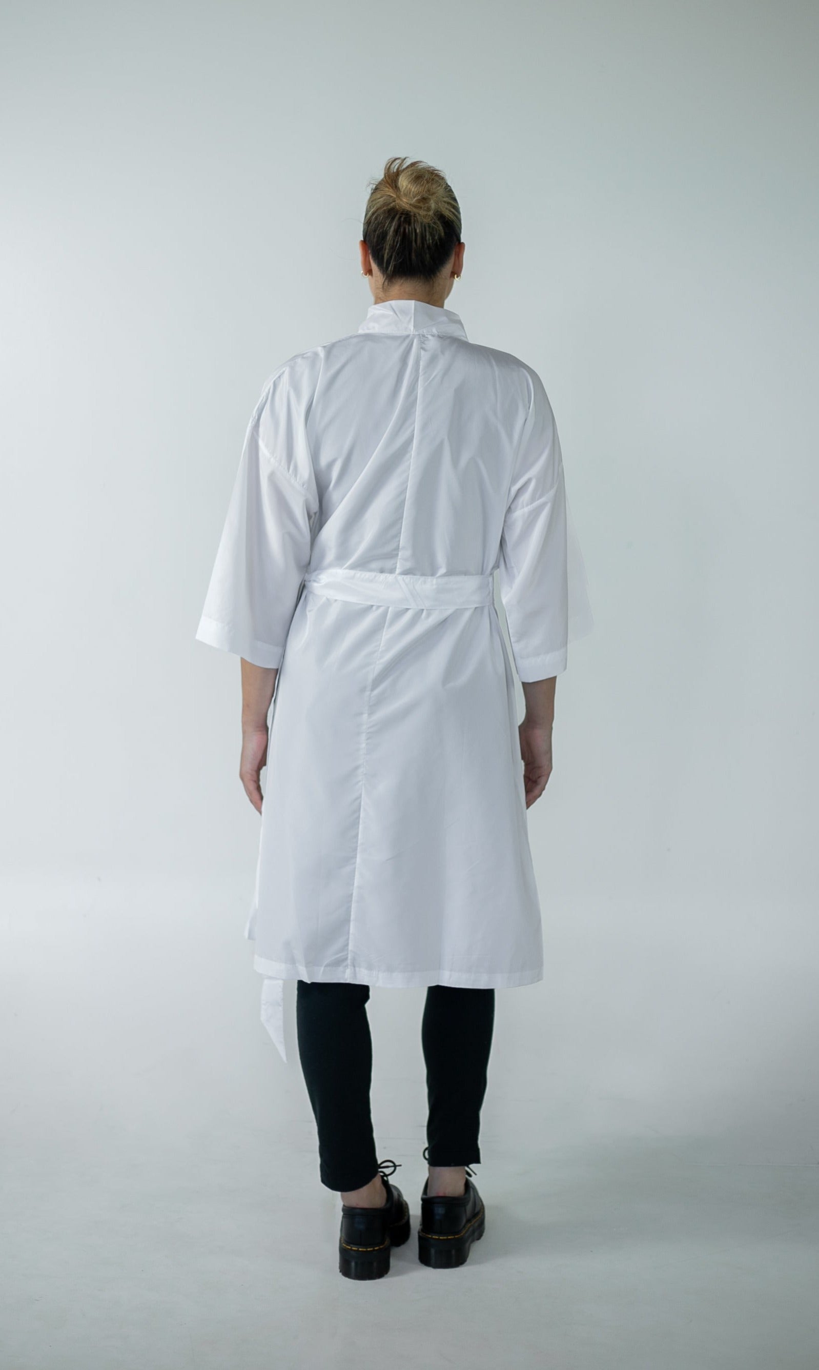 The back view of a woman dressed in a flowing white robe