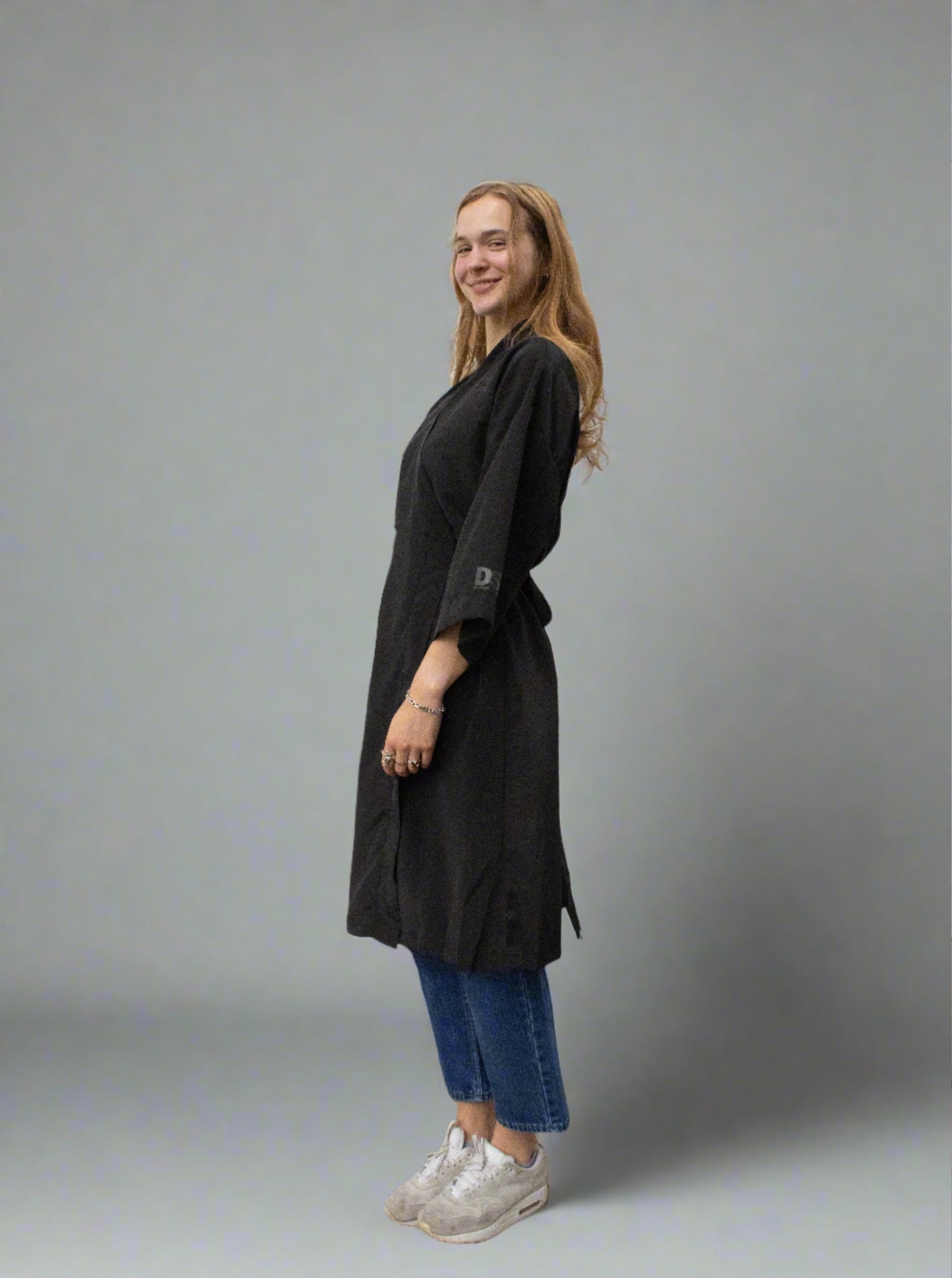 A black dress posing against a solid backdrop